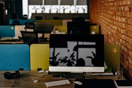 Reunión profesional en oficina con documentos físicos y laptop sobre la mesa.