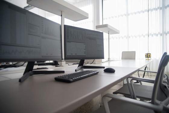 Espacio de trabajo con múltiples monitores y equipo tecnológico para operación e infraestructura.